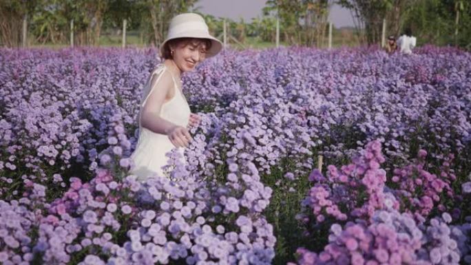 年轻的微笑和大笑黑发女人享受日落时花园的味道