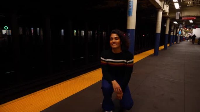 年轻的多种族西班牙裔学生女孩在纽约市地铁站玩滑板。