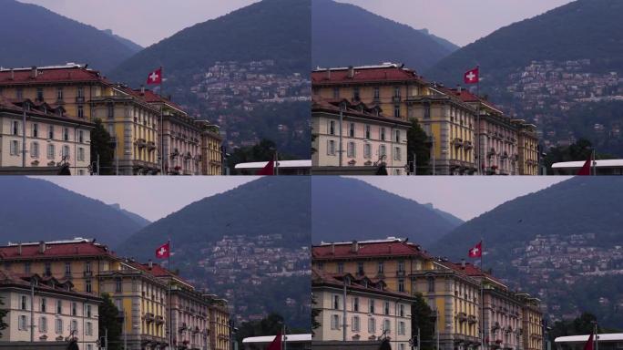 瑞士国旗。卢加诺湖建筑和蒙特布雷山。