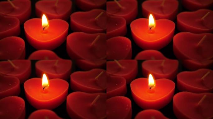 一组未点亮的蜡烛中的一个点亮的心形蜡烛无缝循环概念视频背景