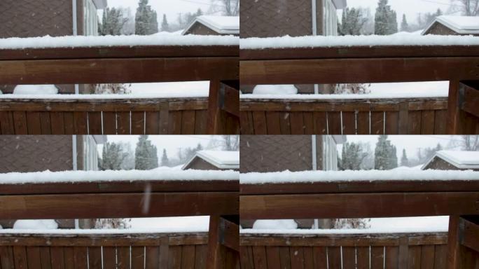 雪落在郊区后院的木栏杆和围栏上