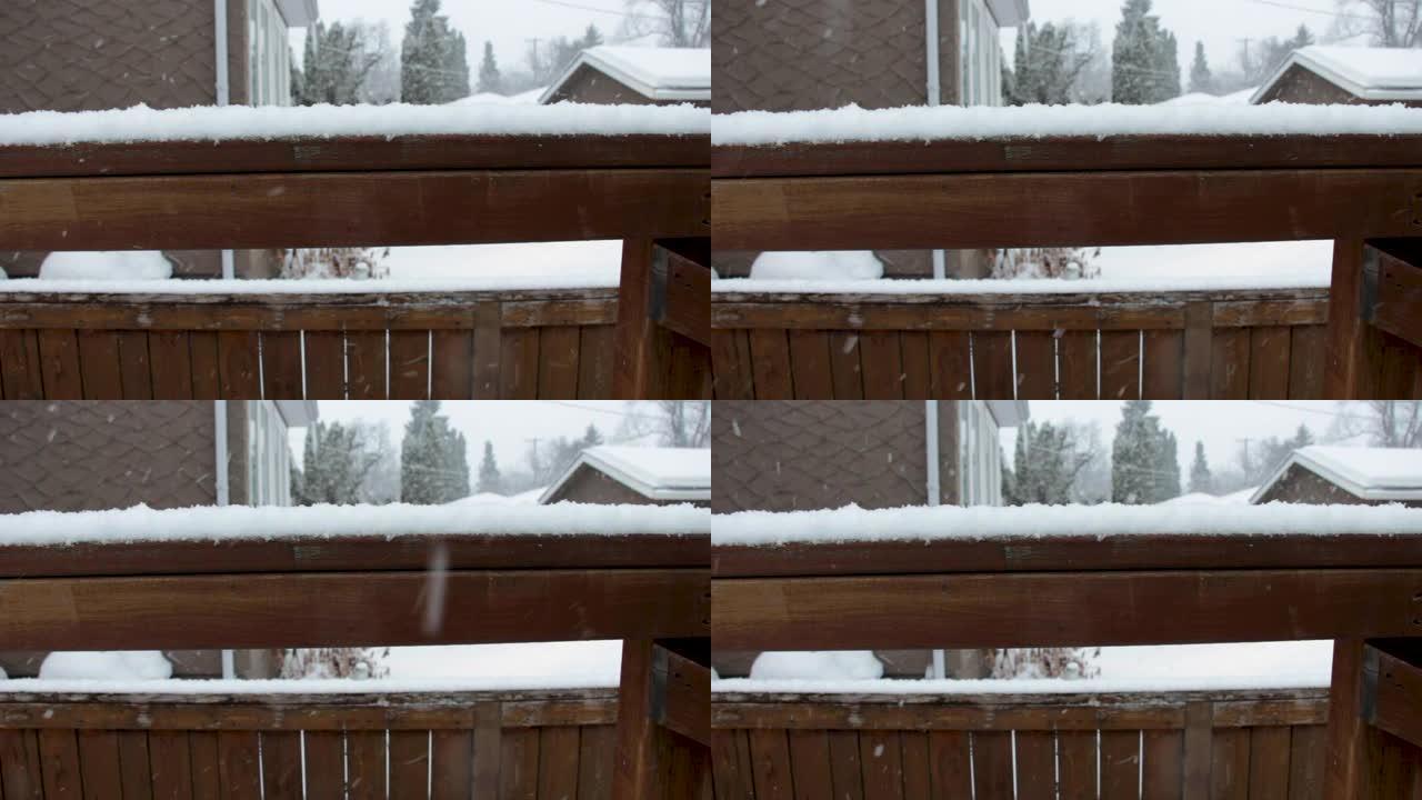 雪落在郊区后院的木栏杆和围栏上