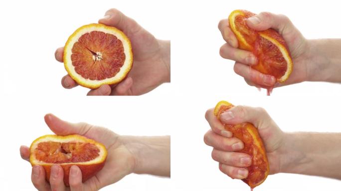面目全非的人挤压一半血橙的特写。新鲜柑橘汁下降。孤立，在白色背景上