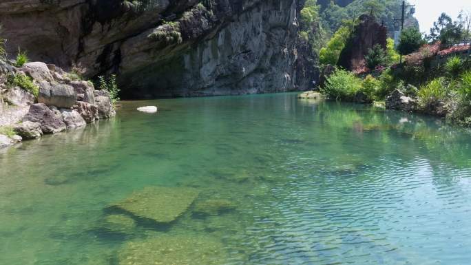 4k航拍碧绿溪水与岩石山洞