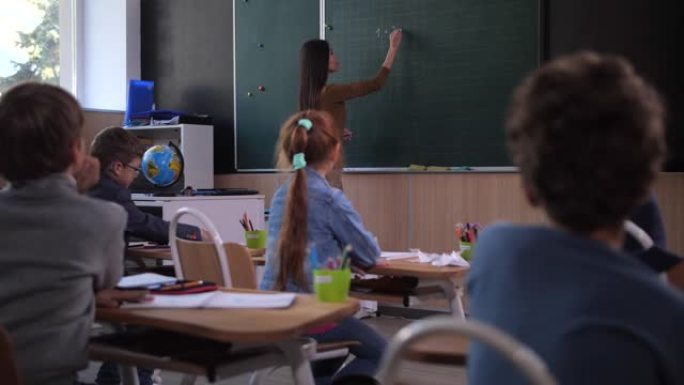 女教师在黑板上写数学方程