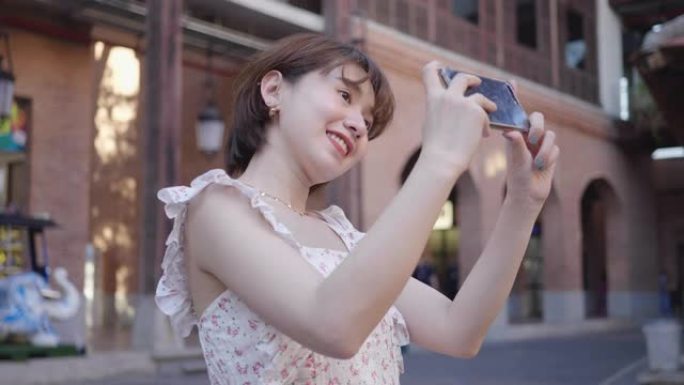 年轻女性用手机与城市街道合影
