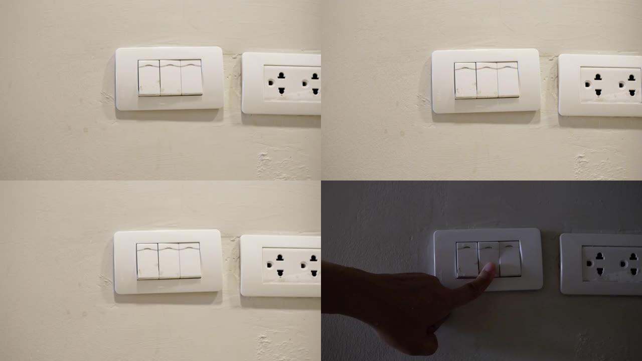 女性手或手指的特写湿润在家的夜晚，白色墙壁上的白灯开关关闭。节省电力。不要用湿手用电和安全的概念。