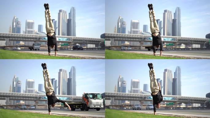 杂技演员一方面与模糊的迪拜城市景观保持平衡。现代健康生活方式的概念。