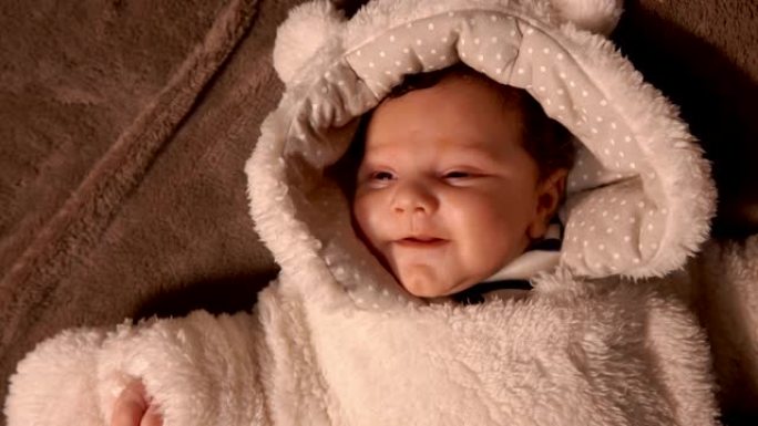 毛绒泰迪熊custume的婴儿躺在毯子上
