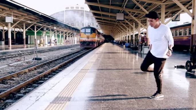 年轻的潮人在等待火车时在火车站做自由式街舞。亚洲男人。