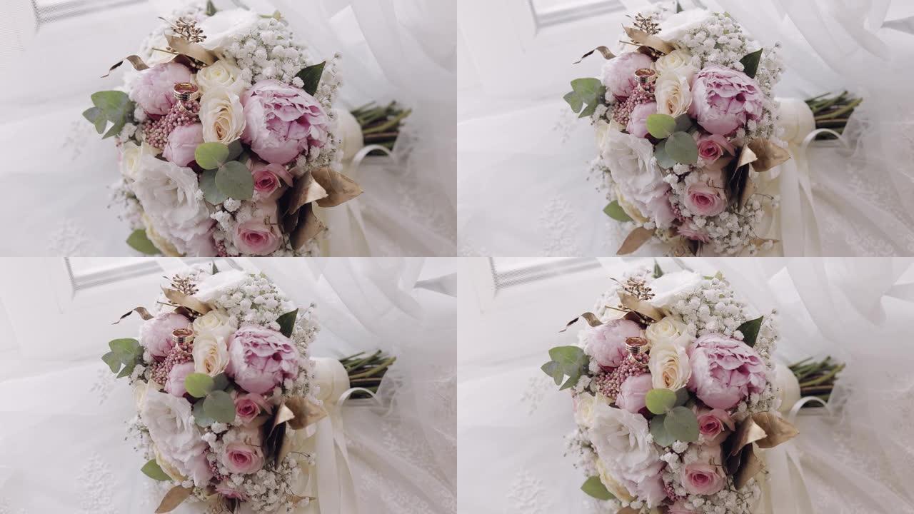 美丽的婚礼花束躺在白色窗帘上的窗户附近的结婚戒指上