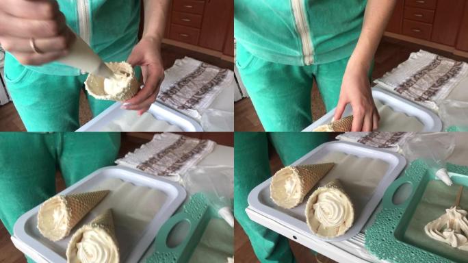 烹饪棉花糖。一名妇女使用糕点袋和喷嘴在华夫饼蛋筒中填充棉花糖。把它放在托盘上。