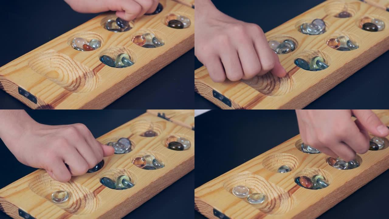 木制mangala游戏，mangala游戏板和玻璃弹珠，黑色背景