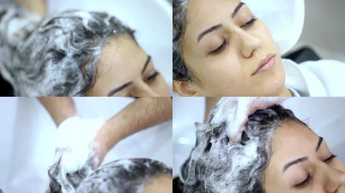 一个无法识别的美发师在美发沙龙洗年轻女子头发的实时视频拍摄