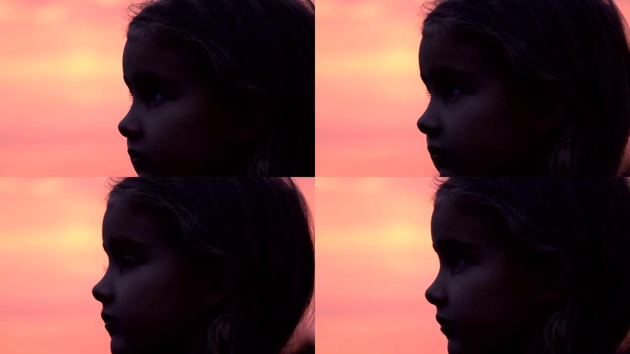 孩子抬头看着大自然的天空。小女孩祈祷着希望仰望紫色的天空，特写。