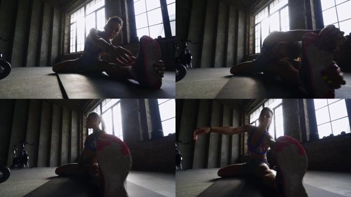 女孩在现代健身房的地板上伸展