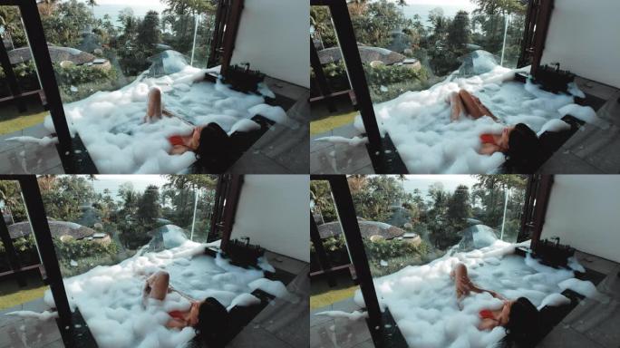 亚洲女性在户外沐浴中放松，配有热带海洋豪华水疗酒店，生活方式理念