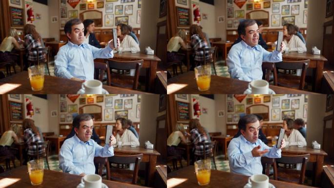 小男人在咖啡馆的智能手机上进行视频通话