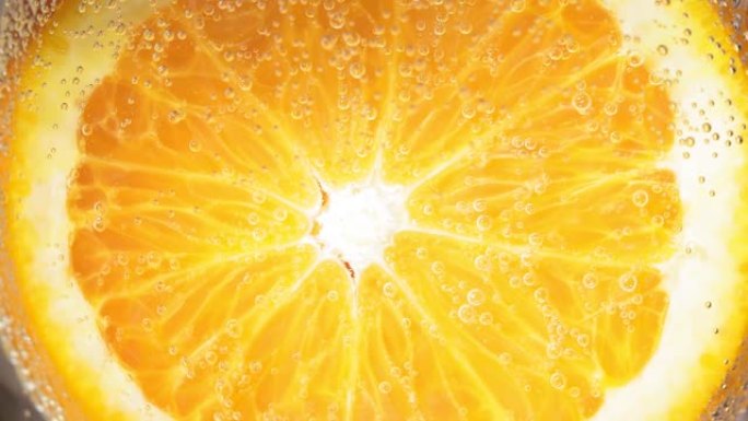 水滴或果汁成熟橙子的特写镜头。水果散发出新鲜感和汁液。水果的饮食和健康食品概念