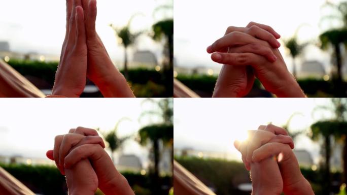双手结合在一起的特写镜头，背景中的阳光耀斑。两个恋人之间美丽的浪漫时刻