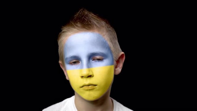 可悲的乌克兰足球队球迷。脸上涂着民族色彩的孩子。