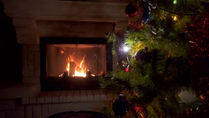 惊人的圣诞树闪烁七彩灯花环在壁炉附近燃烧着火炉