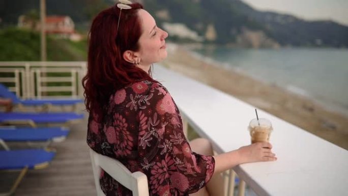 海上度假的女人一边看日落一边享受弗雷多浓缩咖啡