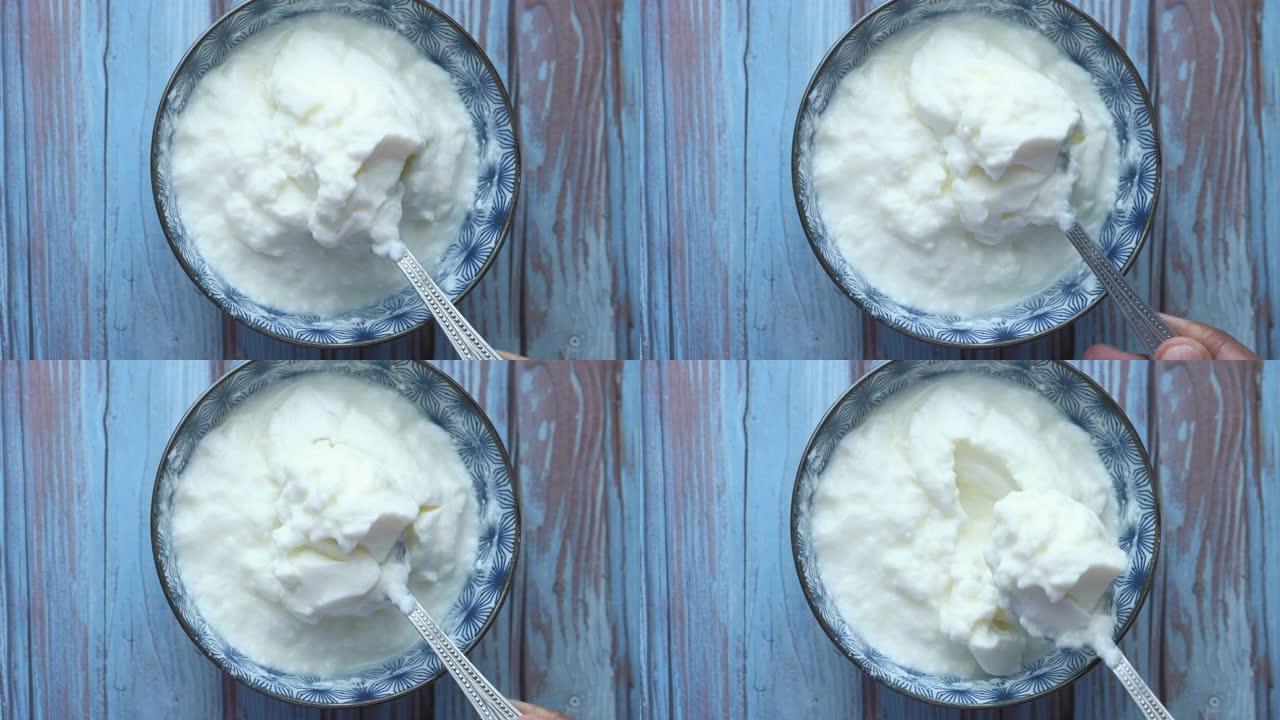 希腊酸奶放在乡村木桌上的木碗中