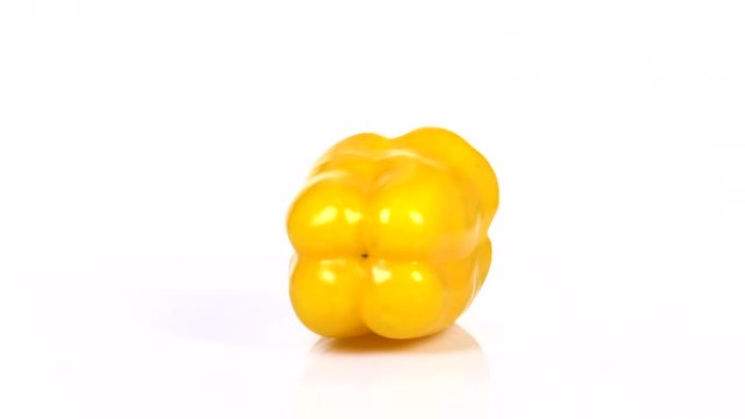 一个新鲜的黄辣椒在白色背景上旋转的无尽循环。侧视图。