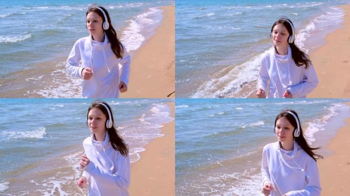 戴着耳机的女孩音乐在沙滩上慢跑运动进行户外训练。