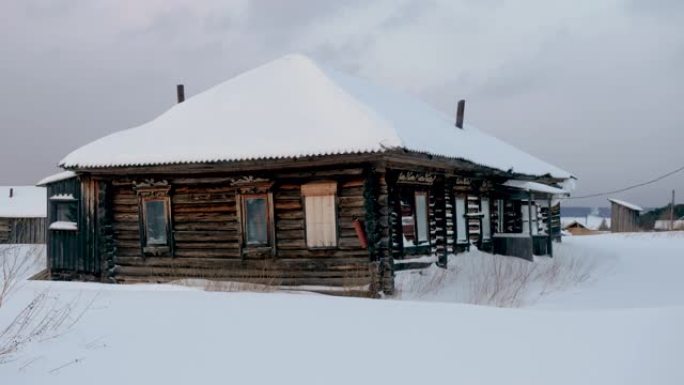 覆盖着冰雪的木屋抵御着冰冻的叶尼塞河。冬季景观中的俄罗斯村庄。西伯利亚。4K