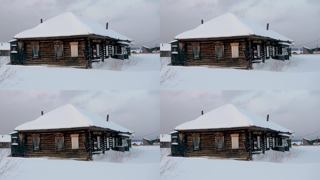 覆盖着冰雪的木屋抵御着冰冻的叶尼塞河。冬季景观中的俄罗斯村庄。西伯利亚。4K