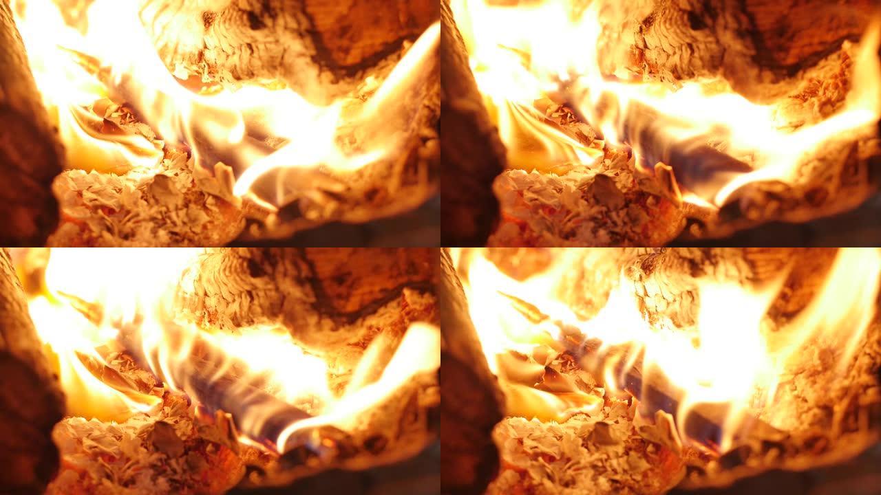 树在壁炉里燃烧得很漂亮。雄性手把柴火放在炉子里。壁炉里燃烧着火。4K.中等火焰壁炉环夹