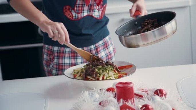 女人躺着把牛肉从锅里拿出来，和蔬菜混合。厨师在黄瓜中加入熟肉