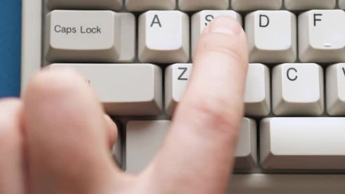 男性手指按下白色键盘上的CTRL按钮。慢动作和宏观视图