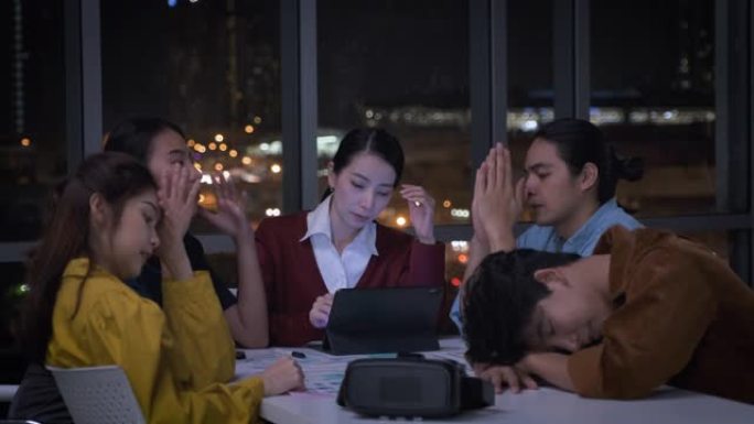 亚洲女性领导者和ux/ui设计师晚上在现代办公室严肃地讨论手机应用界面线框设计的截止日期。工作到很晚
