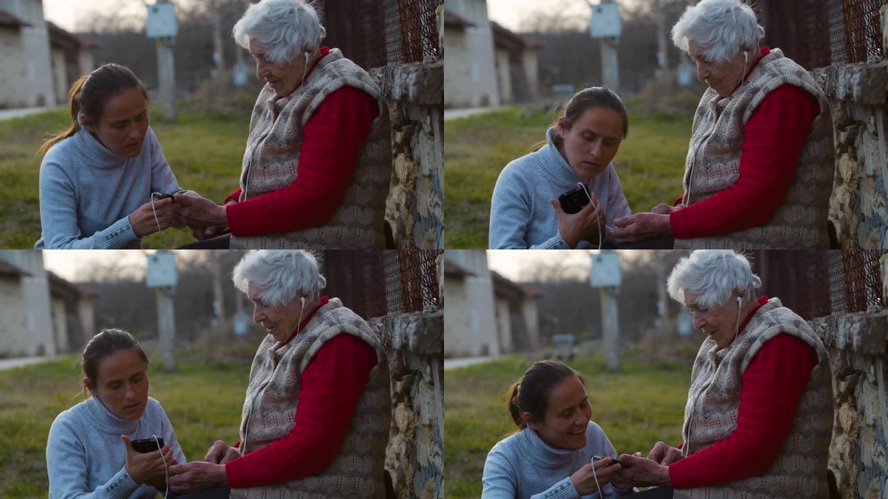 伸出援助之手。年轻女子用一套耳机和电话向祖母解释如何听音乐。