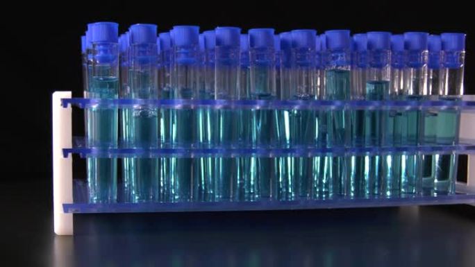 实验室中蓝色液体在黑色背景上旋转的试管