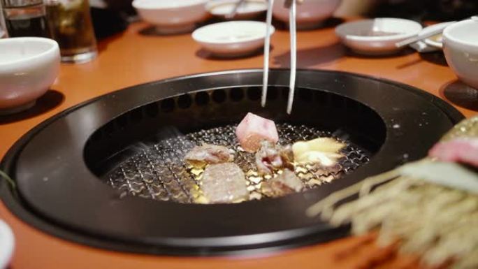 年轻的亚洲夫妇在日本火上吃和煮和牛牛肉。