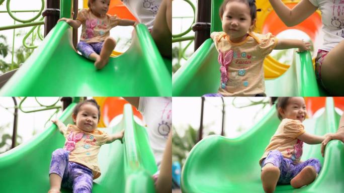 亚洲女婴和母亲在公园的操场上玩滑梯，幸福的家庭概念。4k手持镜头，真实生活