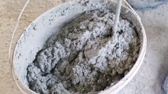 瓦工在桶中搅拌水泥
