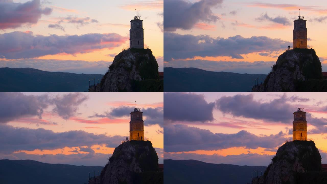 日落时，冬季岩石顶部的Arachova-Parnassos钟楼过度流失