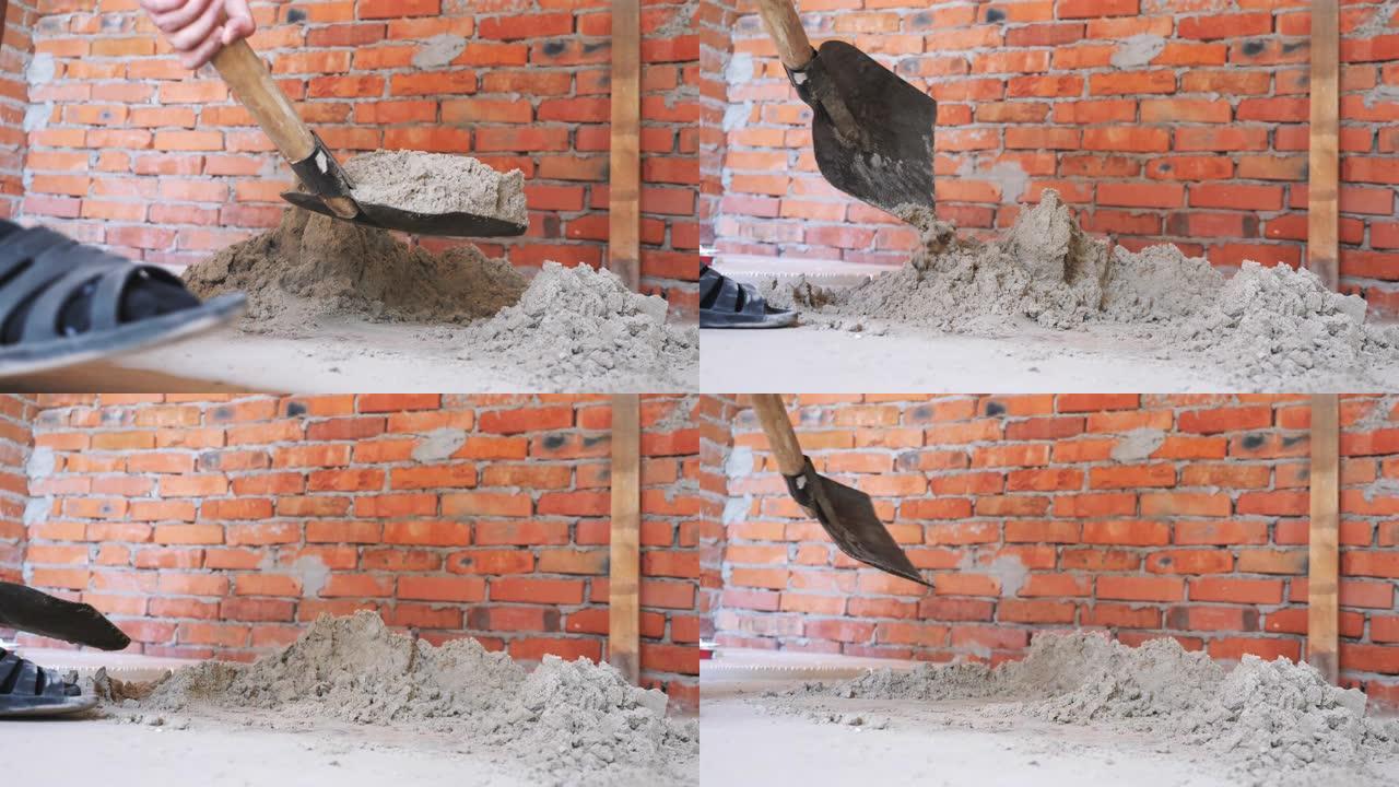 铲子挖沙。手握铲子在红砖墙附近挖沙。施工概念