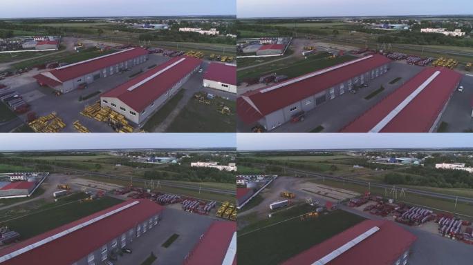 工业工厂的领土。红色屋顶的大型机库。鸟瞰图，晚间拍摄