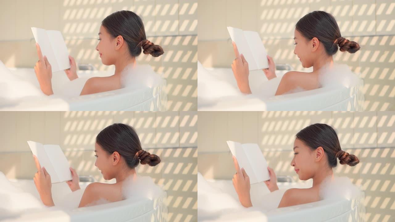 年轻的亚洲女性在浴缸里看书放松