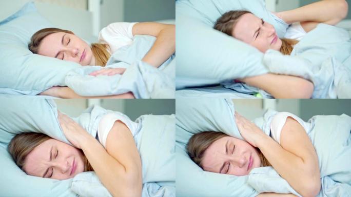 恼怒的女人试图睡觉被糟糕的嘈杂的房间邻居用枕头遮住耳朵，愤怒的女学生被吵闹的问题打扰醒来躺在床上失眠