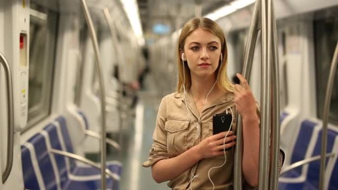 拥有智能手机的女人进入地铁车厢