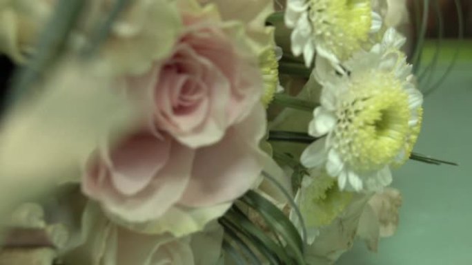 在木棍框架上构图一束白玫瑰和菊花