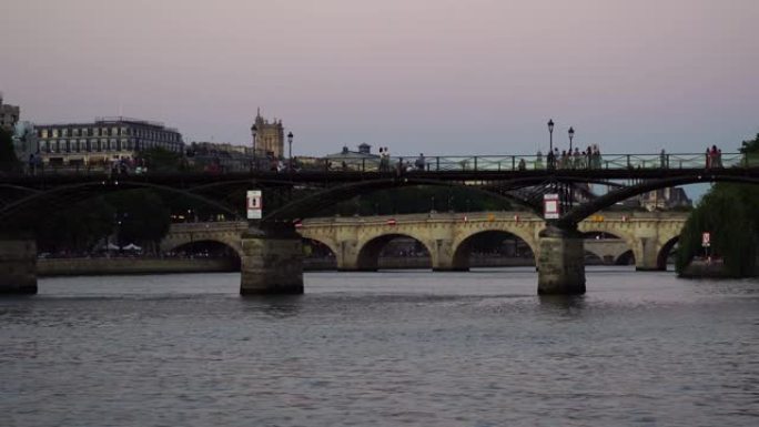 蜜月情侣在巴黎的桥上接吻。日落之光城市景观。