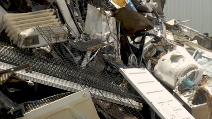 金属垃圾被扔进一堆回收的金属和电器中